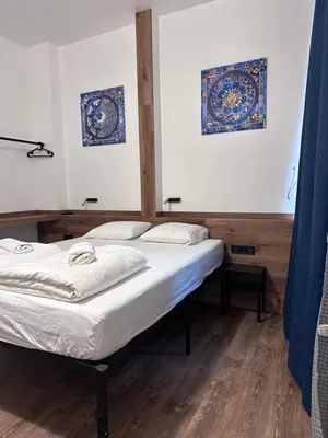two beds in a room with blue curtains at Gallery Hotel SIS in Prague