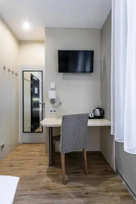 a room with a desk with a chair and a tv at Ametyst Hotel Praha in Prague