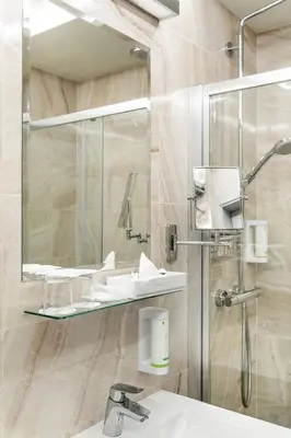 a bathroom with a sink and a shower with a mirror at Ametyst Hotel Praha in Prague