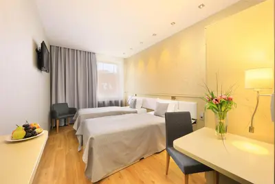 a hotel room with two beds and a table at Ametyst Hotel Praha in Prague