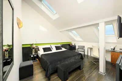 a bedroom with a king sized bed and a couch at Ametyst Hotel Praha in Prague