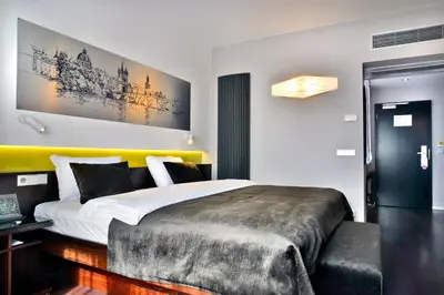 a bedroom with a large bed with a yellow headboard at Ametyst Hotel Praha in Prague