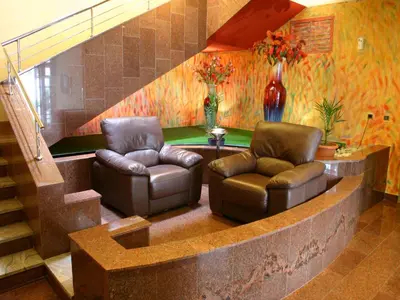 a lobby with two leather chairs and a staircase at EA Hotel Crystal Palace in Prague