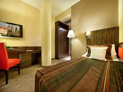 a hotel room with a bed and a desk at EA Hotel Crystal Palace in Prague