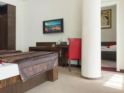 a bedroom with a bed and a desk with a red chair at EA Hotel Crystal Palace in Prague