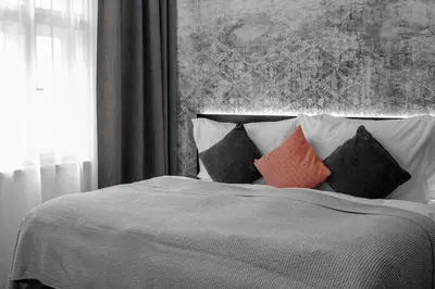a bedroom with a bed with pillows and a painting at THE MANES Boutique Hotel Prague in Prague
