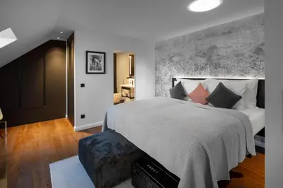 a bedroom with a large bed with a large wall at THE MANES Boutique Hotel Prague in Prague
