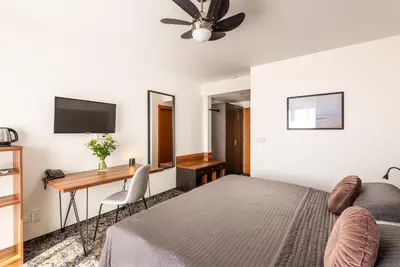 a bedroom with a bed and a desk at Hotel Troja in Prague