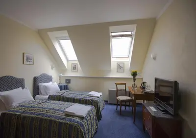 a hotel room with two beds and a television at Hotel Tyl in Prague