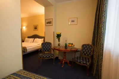 a hotel room with a table and chairs and a bed at Hotel Tyl in Prague
