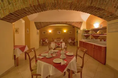 a dining room with a table and a kitchen at Hotel Tyl in Prague
