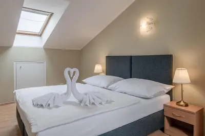 two white swans sitting on top of a bed at Hotel Brixen in Prague