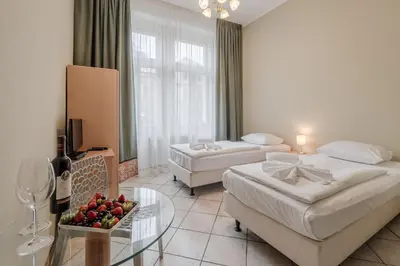 a hotel room with two beds and a table with fruit at Hotel Brixen in Prague