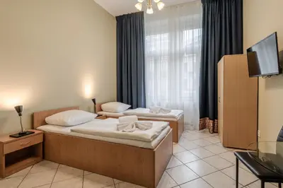 a hotel room with two beds and a television at Hotel Brixen in Prague