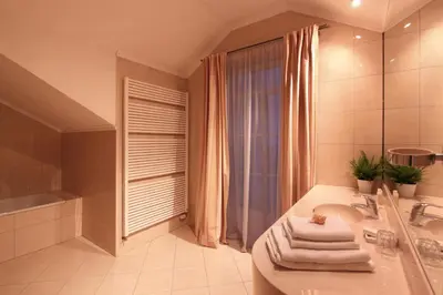 a bathroom with a tub and a sink and a shower at Hotel Angelis in Prague
