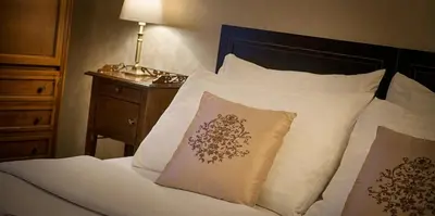 a bedroom with a bed with white sheets and pillows at Hotel Angelis in Prague