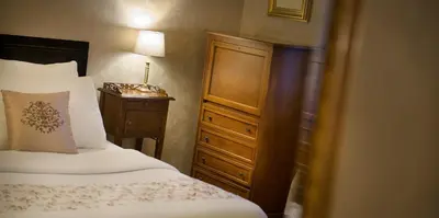 a bedroom with a bed and a dresser with a lamp at Hotel Angelis in Prague
