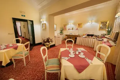 a dining room with two tables and chairs in a room at Hotel Angelis in Prague