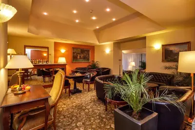 a hotel lobby with couches and tables and chairs at Hotel St George - Czech Leading Hotels in Prague