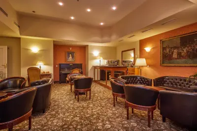 a waiting room with leather chairs and a bar at Hotel St George - Czech Leading Hotels in Prague