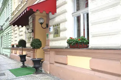 a building with a red awning on a street at Hotel Malá Strana in Prague