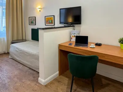 a room with a desk with a laptop and a bed at Hotel Malá Strana in Prague