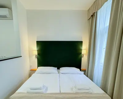 a bed in a room with a green headboard at Hotel Malá Strana in Prague
