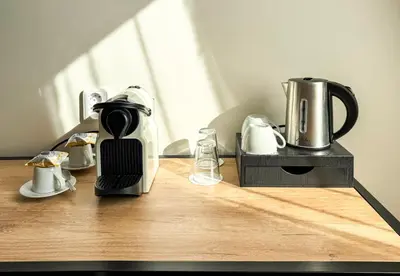 a coffee maker sitting on a wooden table with a coffee pot at Hotel Malá Strana in Prague