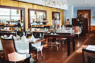 a dining room with tables and chairs in a restaurant at Golden Well in Prague
