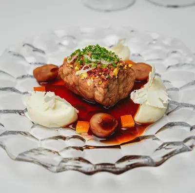 a plate of food with a piece of meat and vegetables at Golden Well in Prague
