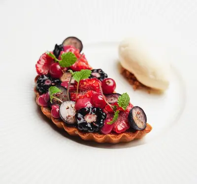 a fruit tart on a plate on a white plate at Golden Well in Prague