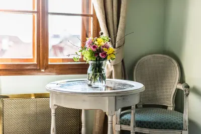 a vase of flowers on a table with two chairs at Golden Well in Prague