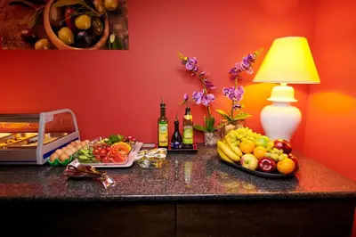 a table with fruits and bottles of wine and a lamp at La Boutique in Prague