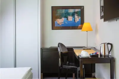 a hotel room with a desk and a table with a lamp at OREA Hotel Angelo Praha in Prague