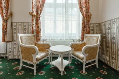 two chairs and a table in a room with a window at Hotel Klarinn Prague Castle in Prague