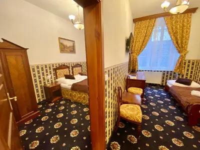 a hotel room with two beds and a chair at Hotel Klarinn Prague Castle in Prague