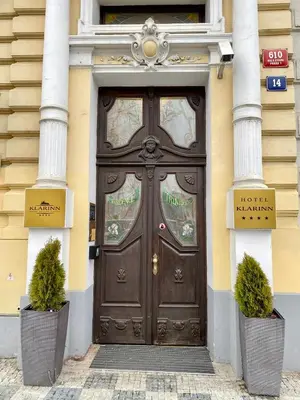 a brown door with two plants in front of it at Hotel Klarinn Prague Castle in Prague