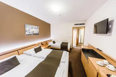 a hotel room with two beds and a flat screen tv at Archibald City in Prague