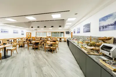 a restaurant with tables and chairs and a buffet at Archibald City in Prague