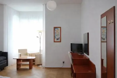a living room with a television and a table at Residence Dykova - former Pension Jana, Domov Mládeže in Prague