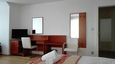a bedroom with a desk and a bed with two chairs at Residence Dykova - former Pension Jana, Domov Mládeže in Prague