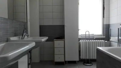 a bathroom with two sinks and a window and a radiator at Residence Dykova - former Pension Jana, Domov Mládeže in Prague