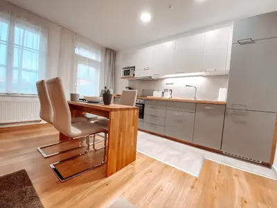 a kitchen with a wooden table and a desk at Residence Masna in Prague