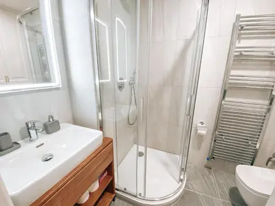 a white bathroom with a shower and a sink at Residence Masna in Prague
