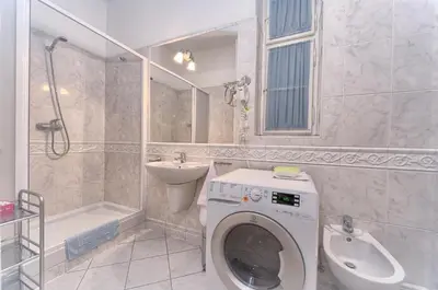 a bathroom with a washing machine and a sink at Residence Masna in Prague