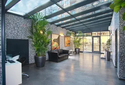 a living room with a couch and potted plants at Hotel Galileo in Prague