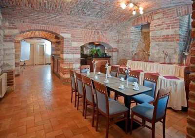a dining room with a table and chairs and a brick wall at Hotel Galileo in Prague
