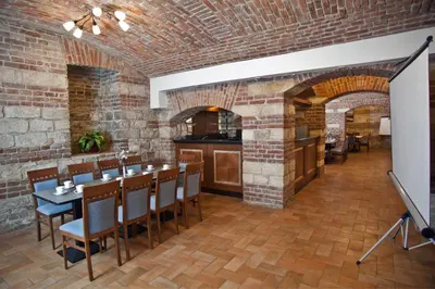 a restaurant with a brick wall and a table and chairs at Hotel Galileo in Prague