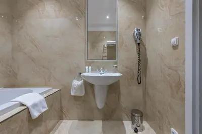 a bathroom with a sink and a mirror and a tub at Monastery Garden Prague in Prague