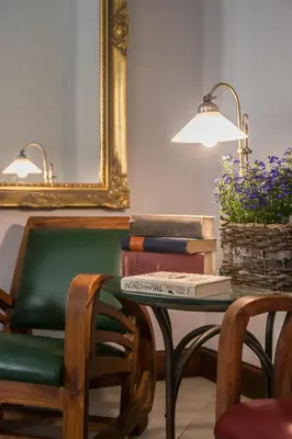 a table with a pile of books and a lamp at Monastery Garden Prague in Prague